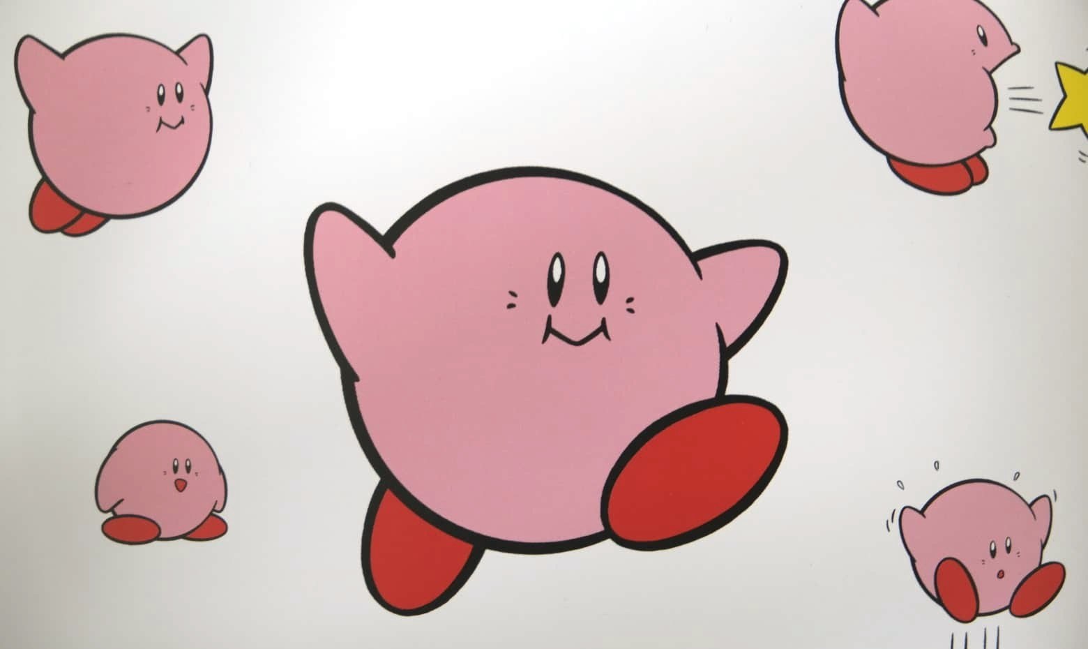 Classic Kirby artwork: flat pink shapes with bold black outlines in several poses
